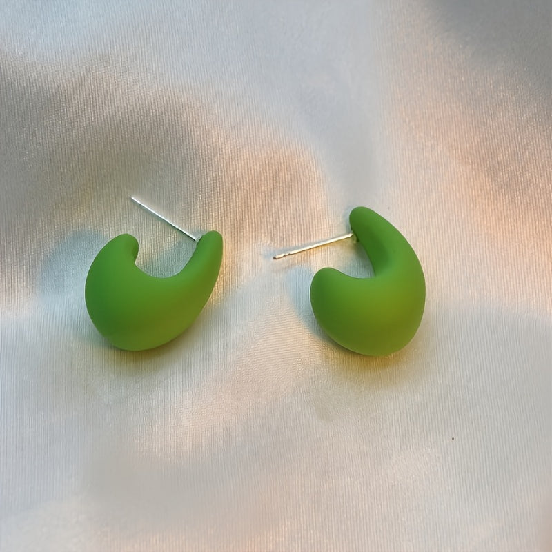 Minimalistische goldene Ohrstecker in skulpturaler C-Form
