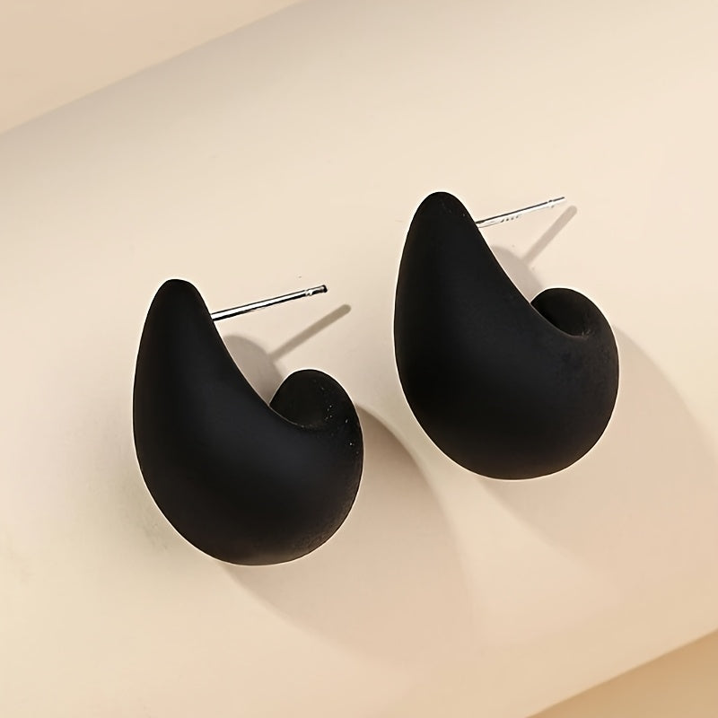 Minimalistische goldene Ohrstecker in skulpturaler C-Form