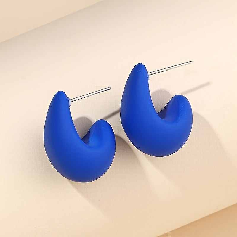 Minimalistische goldene Ohrstecker in skulpturaler C-Form